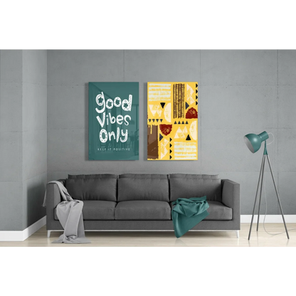 Gray sofa with throw and teal item near Good Vibes Only glass wall art