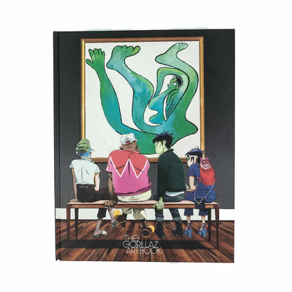 Gorillaz art book with band members looking at a painting featuring Jamie Hewlett