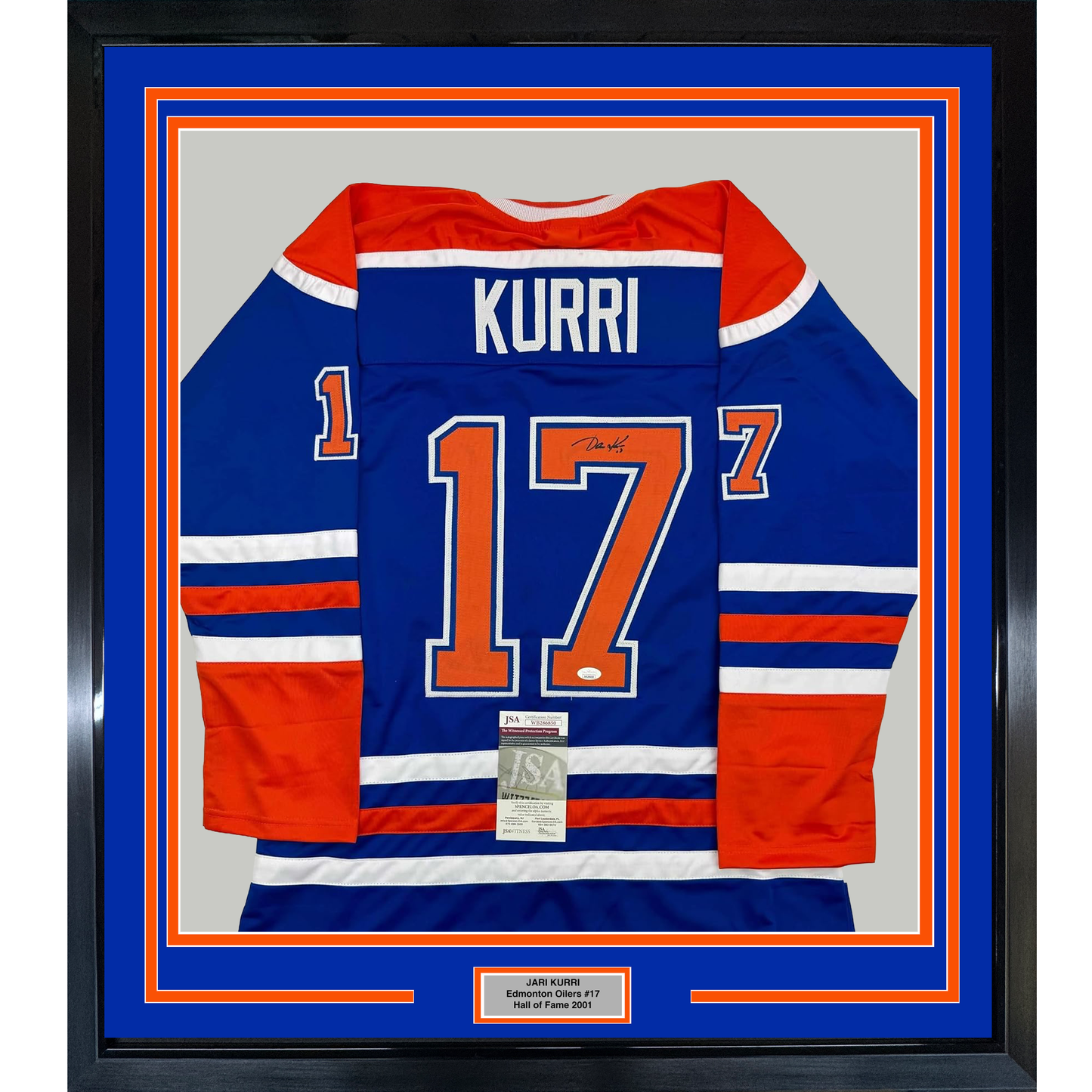Framed Edmonton Oilers #17 Kurri blue jersey with red and white stripes, displayed flat against gray background with authentication certificate visible.