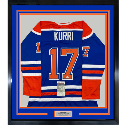 Framed Edmonton Oilers #17 Kurri blue jersey with red and white stripes, displayed flat against gray background with authentication certificate visible.