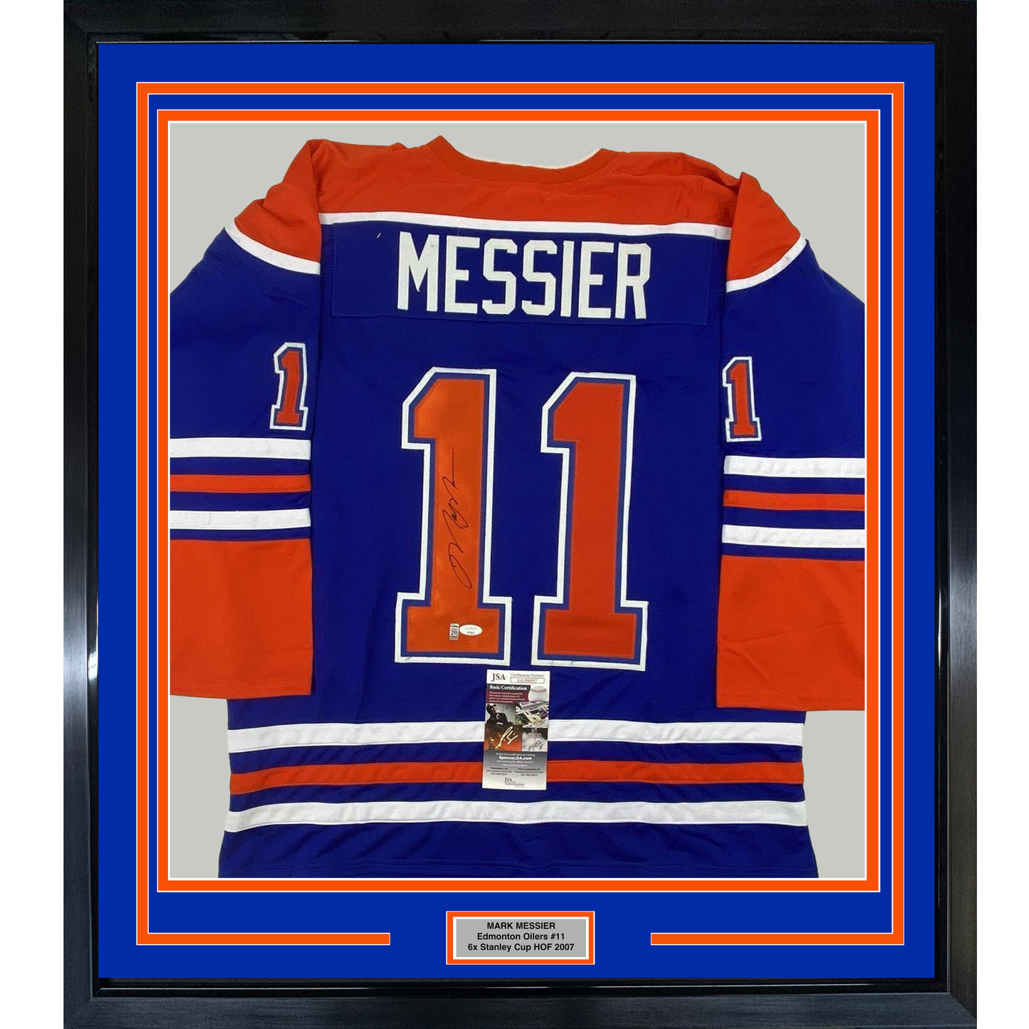Framed Edmonton Oilers blue jersey number 11 with "MESSIER" nameplate, signed, displayed front-facing in blue and orange matting with authentication certificate.