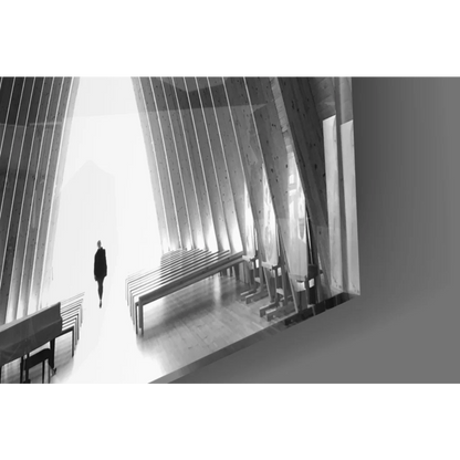 Solitary figure in dark clothes walks modern church with arched beams glass wall art