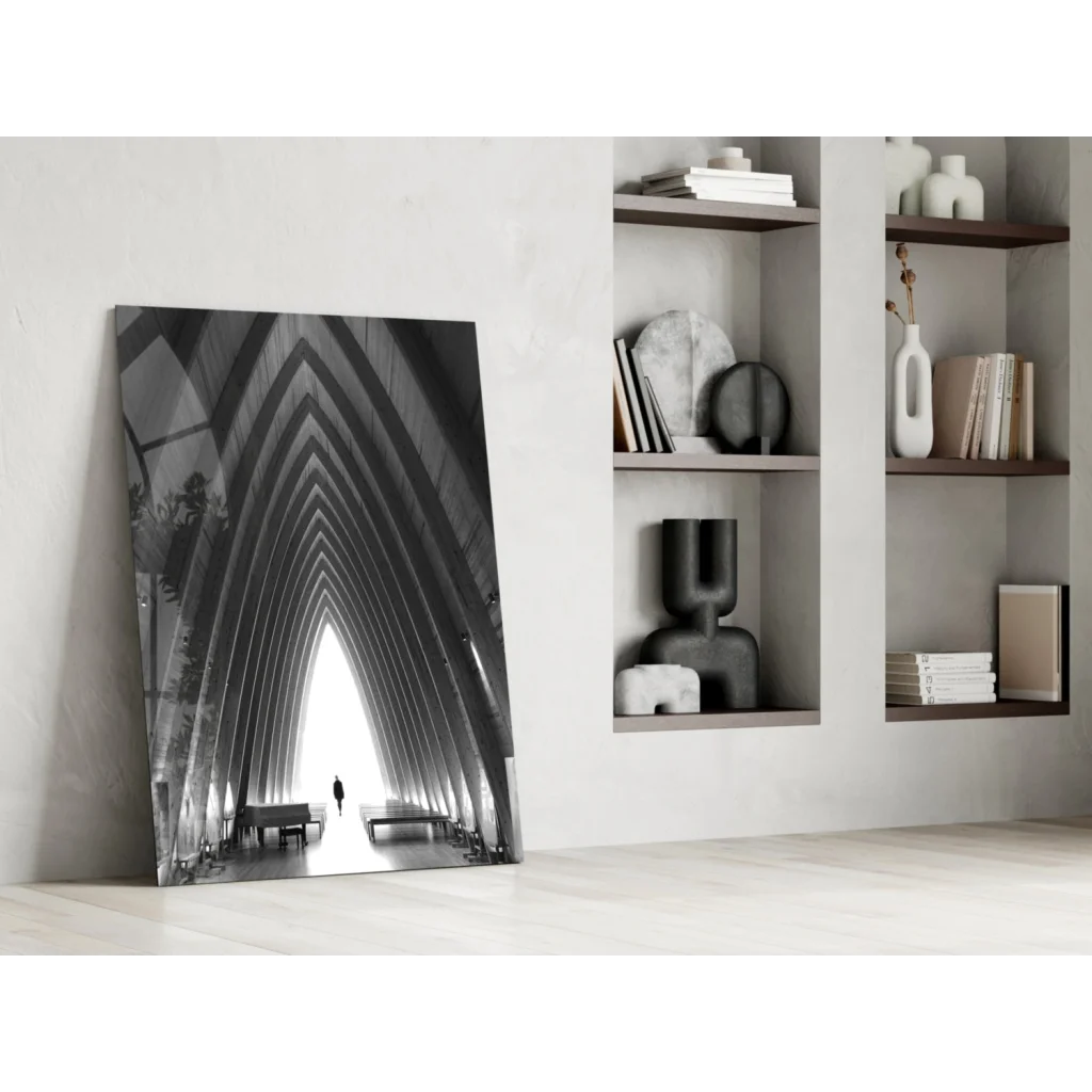 Black-and-white glass wall art of arched beams with lone figure