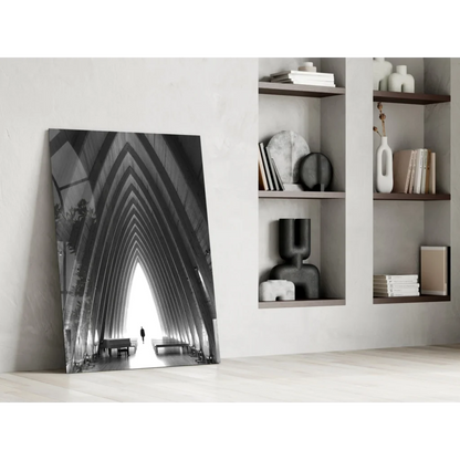 Black-and-white glass wall art of arched beams with lone figure