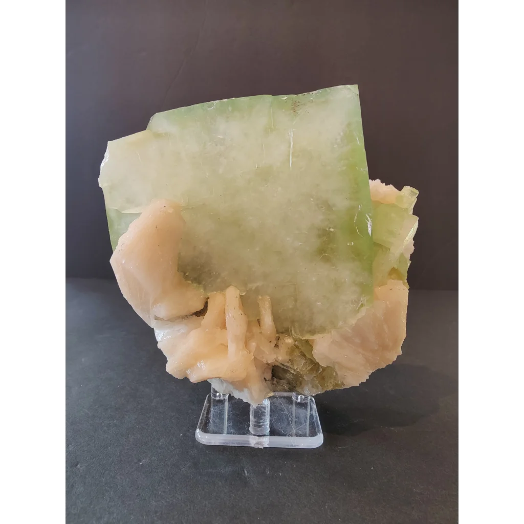 Green apophyllite cube with peach stilbite specimen on acrylic stand