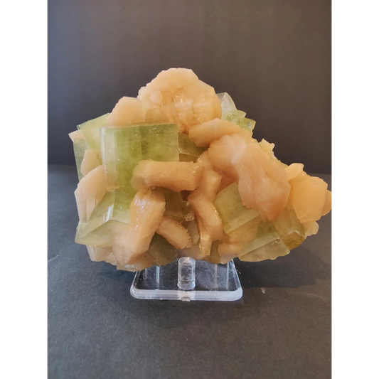 Green apophyllite cubes with peach stilbite specimen on acrylic stand