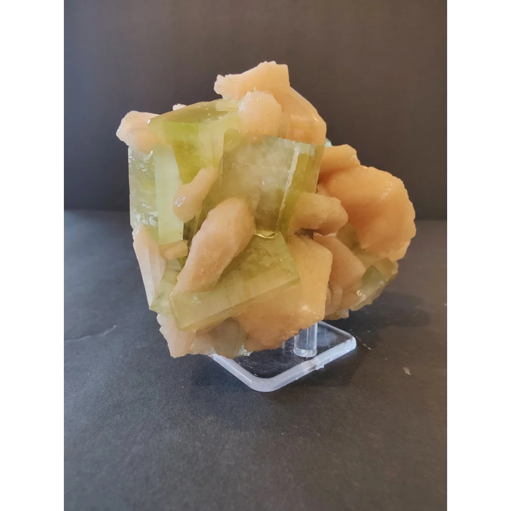 Green apophyllite cubes with peach stilbite specimen on acrylic stand
