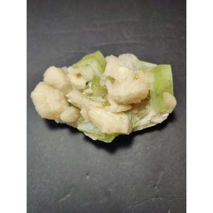 Green apophyllite cubes with peach stilbite specimen on dark surface