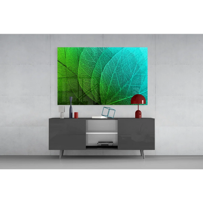Vibrant green and teal leaf canvas wall art above gray console