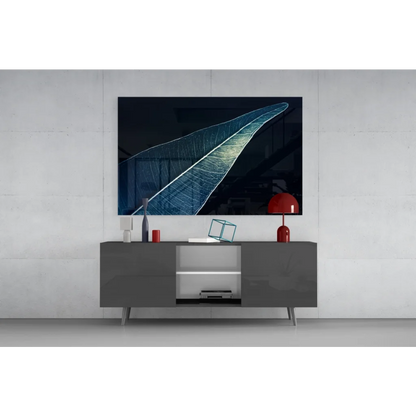 Stunning glass wall art of illuminated leaf on black-blue canvas