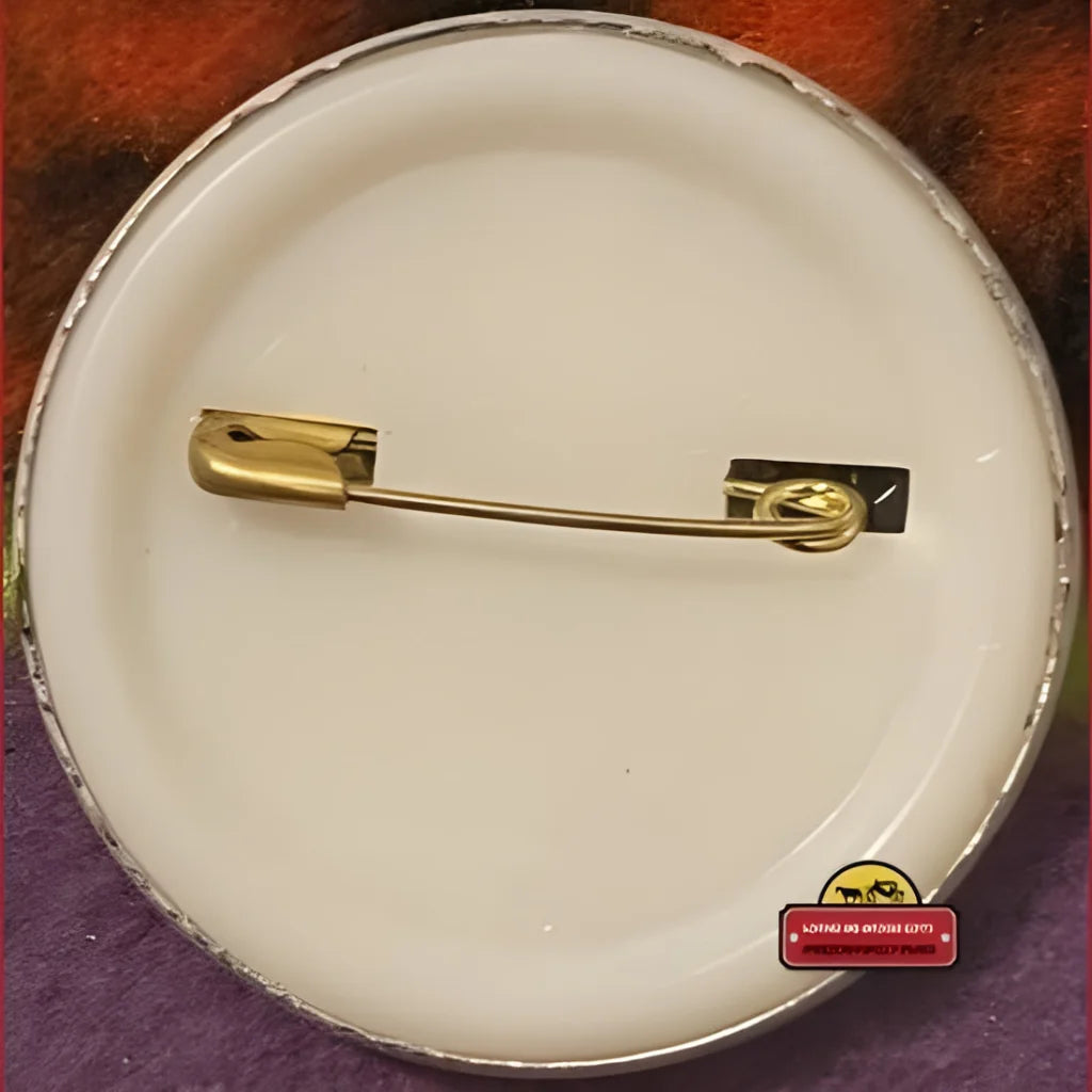 Gold safety pin on a white surface for California Raisin Tin collectible fun