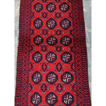 Vibrant red Afghan Baluch hand-knotted wool runner with navy geometric tribal patterns