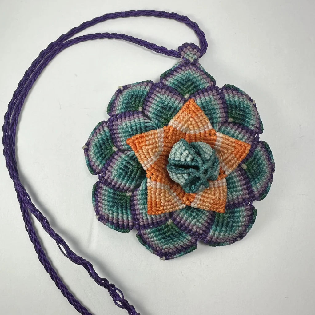 Vibrant hand woven flower necklace with teal, orange, purple crochet pouch
