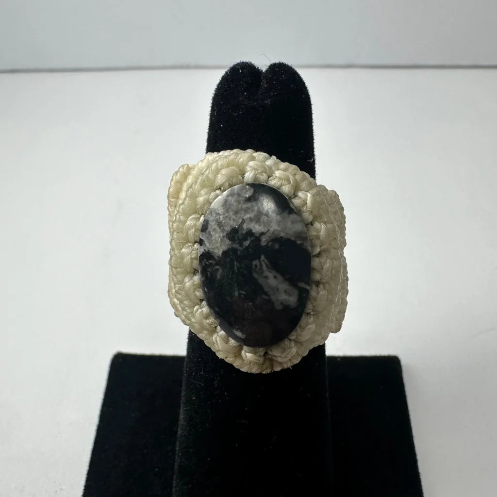 Cream-colored handmade woven ring with oval black and white stone
