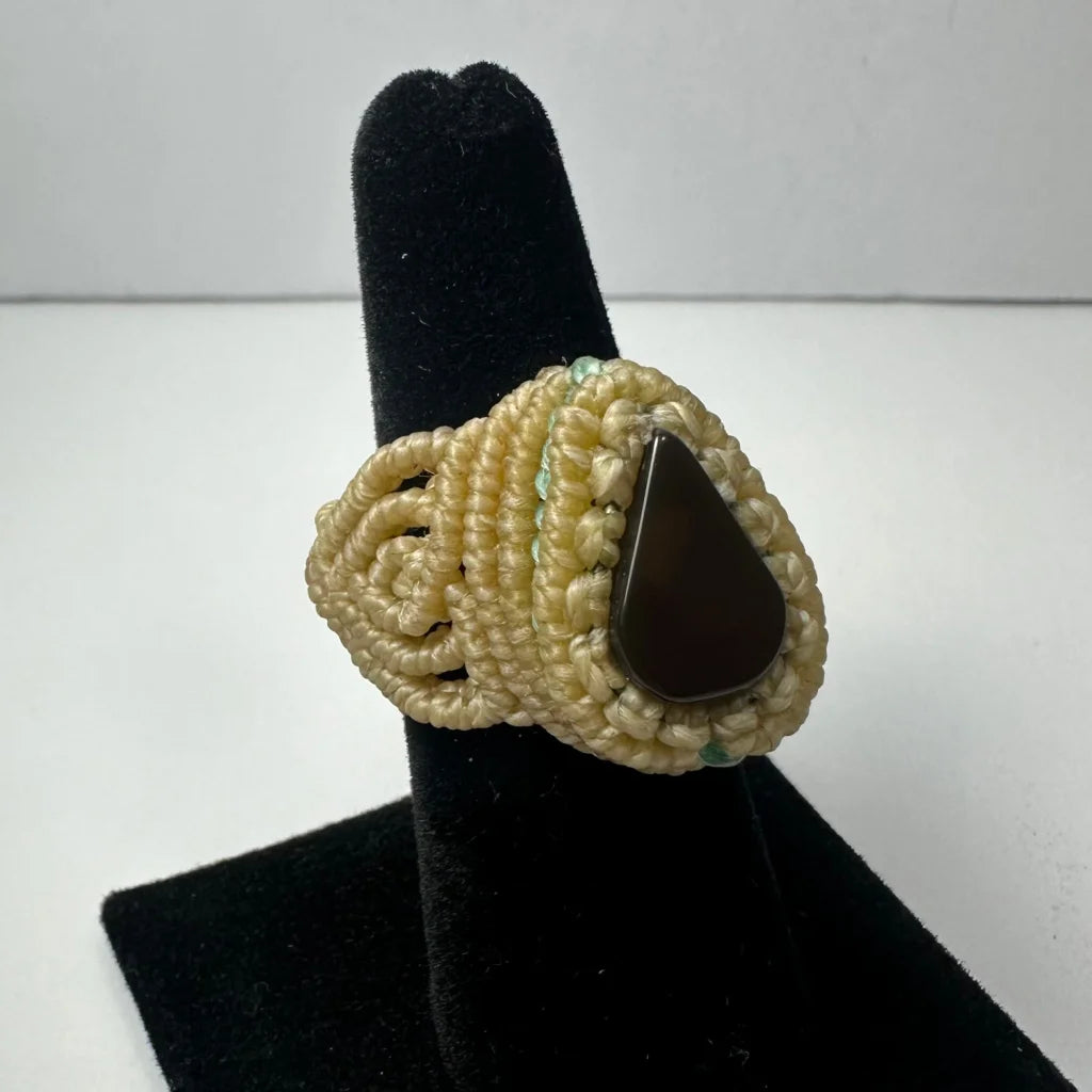 Cream-colored macrame handmade woven ring with dark brown teardrop stone center