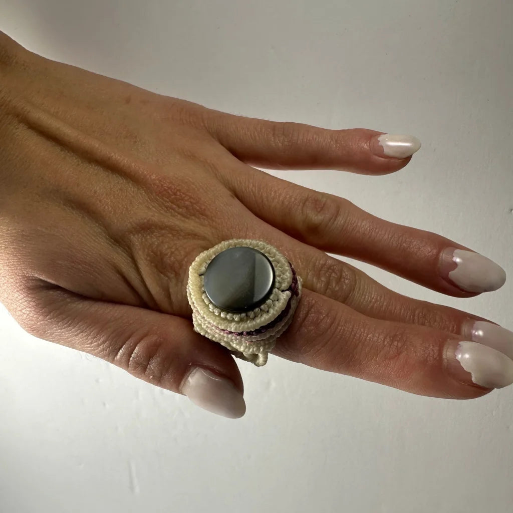Handmade woven ring with dark smooth stone in cream macrame band