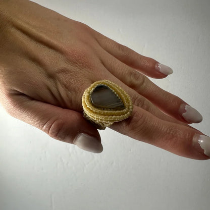 Handmade woven ring with dark teardrop stone in yellow macrame band