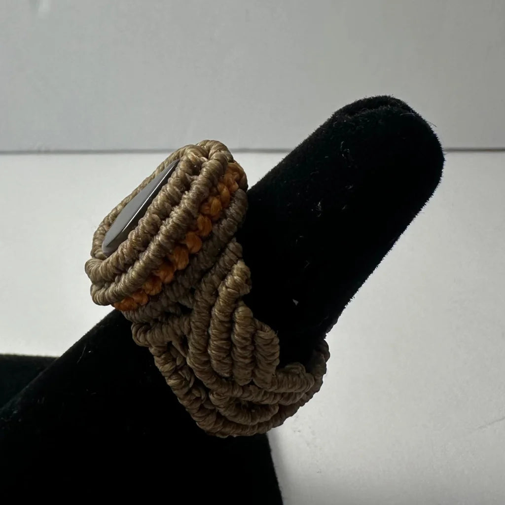 Handmade woven ring with beige tan cord and dark gray stone center