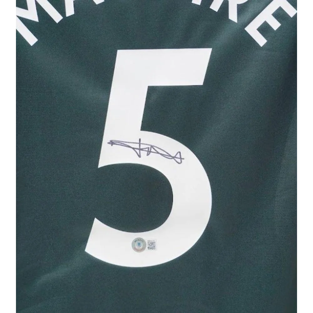 Harry Maguire signed Manchester United away jersey with number 5 on dark green shirt