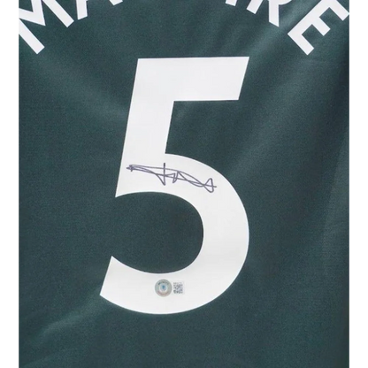 Harry Maguire signed Manchester United away jersey with number 5 on dark green shirt