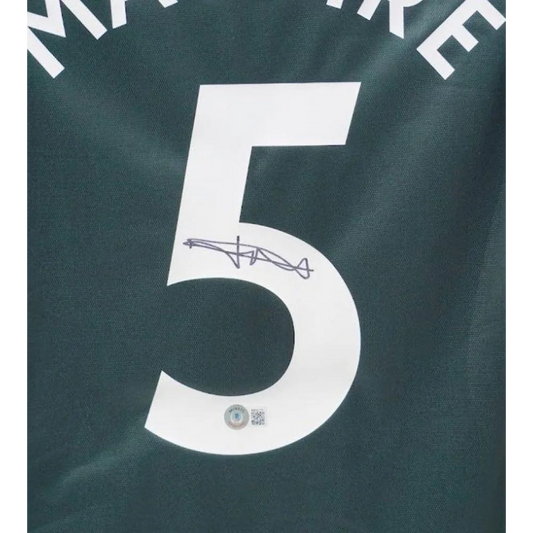 Harry Maguire signed Manchester United away jersey with number 5 on dark green shirt