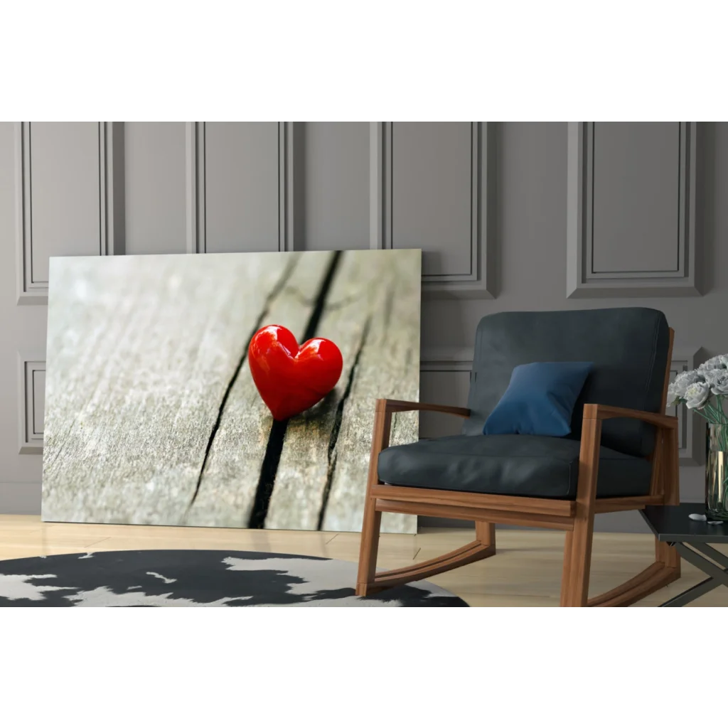 Vibrant red glossy heart glass wall art on gray textured wall