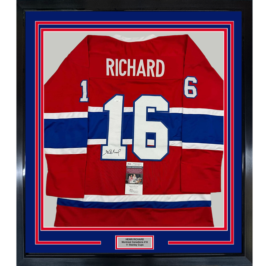 Framed red, white, and blue Montreal Canadiens jersey number 16 signed by Henri Richard, displayed front-facing in protective case.