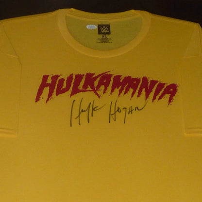 Yellow hulkamania wrestling t-shirt with red graffiti lettering and hulk hogan autographed black ink signature below framed deluxe