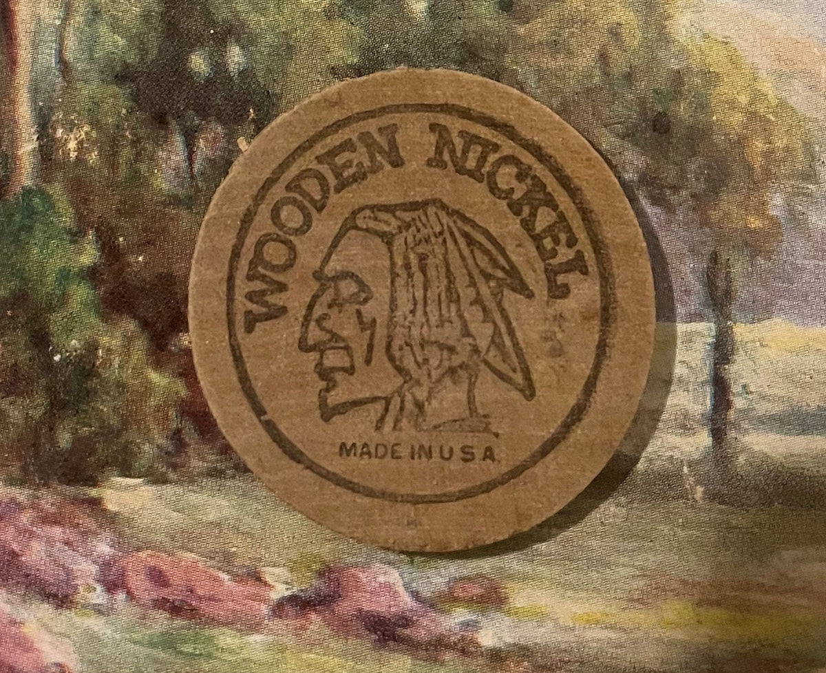 Tan wooden nickel token with embossed Native American profile and "Wooden Nickel" text, marked "Made in U.S.A." on colorful t