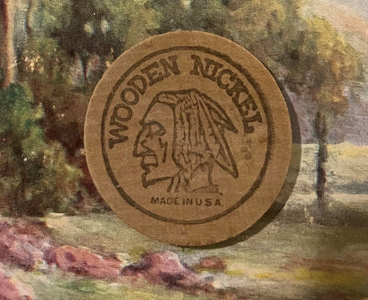 Tan wooden nickel token with embossed Native American profile and "Wooden Nickel" text, marked "Made in U.S.A." on colorful t
