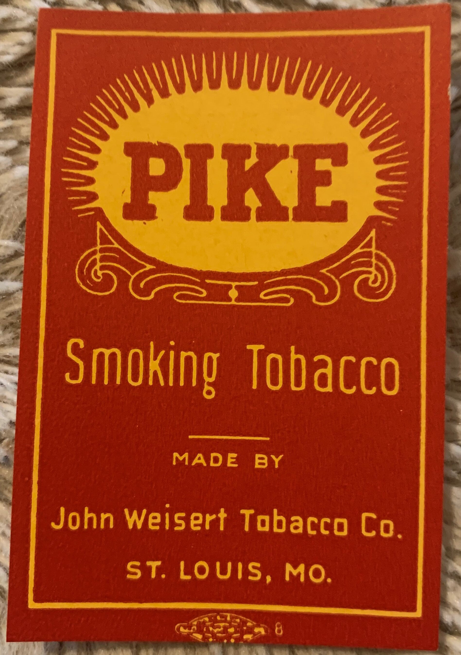 Vintage Pike Smoking Tobacco label with red and yellow design, ornate scrollwork, made by John Weisert Tobacco Co., St. Louis