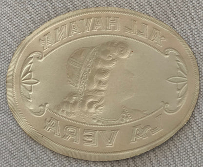 Oval embossed coin or medallion showing profile of woman's head in relief, with text around border in Cyrillic script, displa