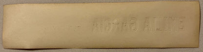 Embossed tan cigar box label with "EMILIA GARCIA" text visible, shown flat against textured fabric background