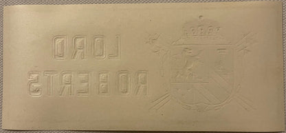 Cream-colored embossed cigar label featuring Cyrillic text reading "ДАД" and "2ТАСЕОА" with a heraldic eagle crest on the right side, photographed flat against fabric background.