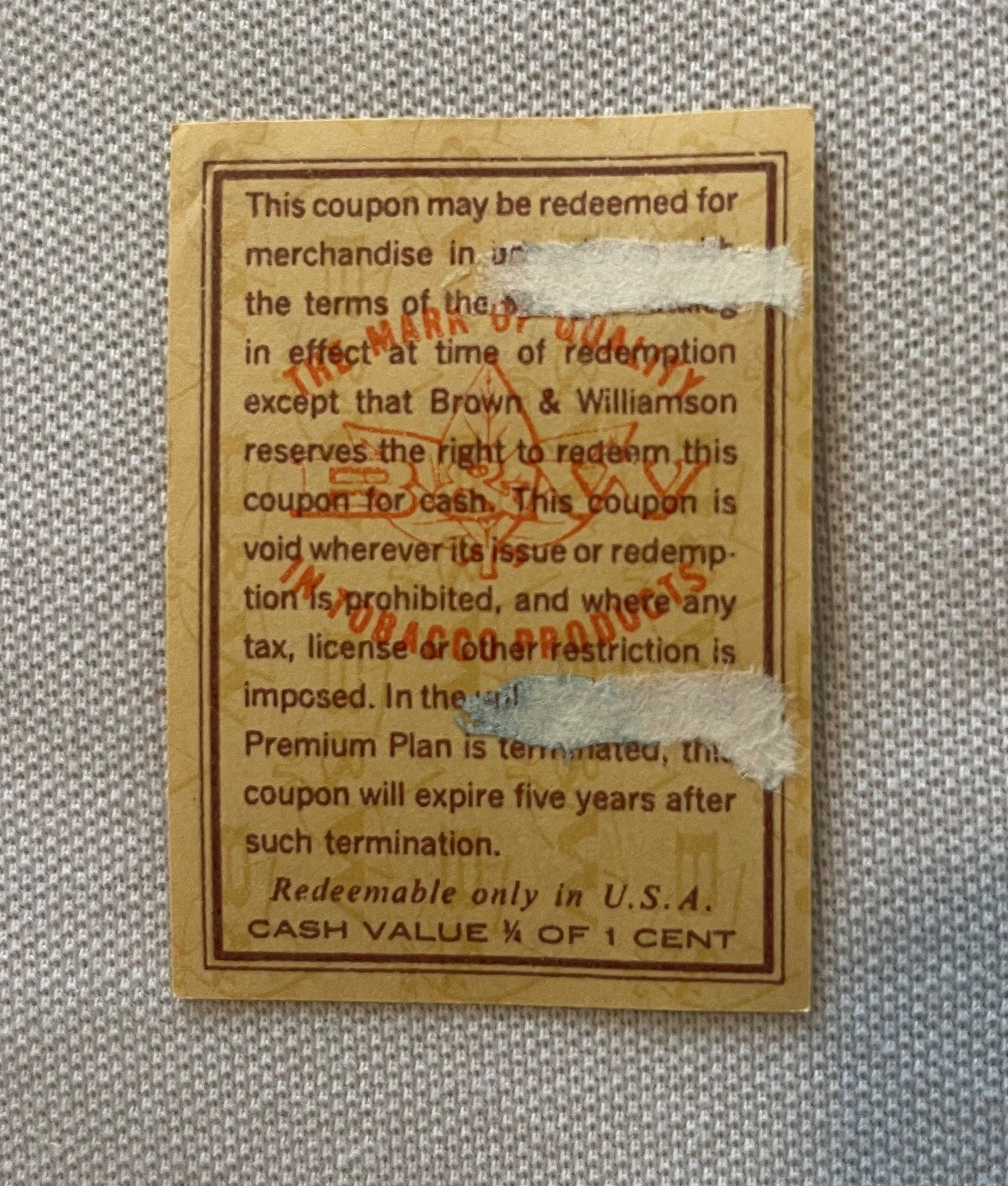 Vintage tobacco coupon from Brown & Williamson with tan background, brown border text, and red "TOBACCO" stamp overlay, cash 