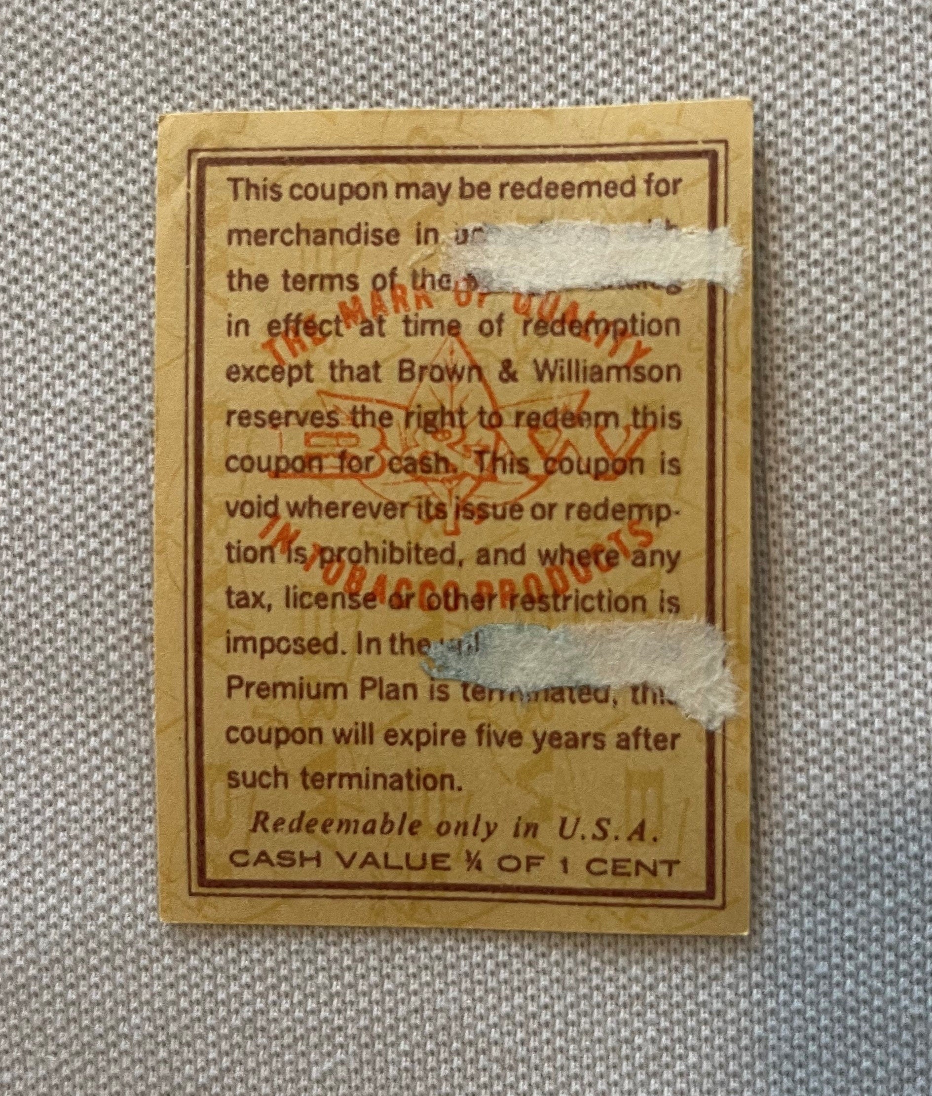 Vintage tobacco coupon from Brown & Williamson with tan background, brown border text, and red "TOBACCO" stamp overlay, cash 