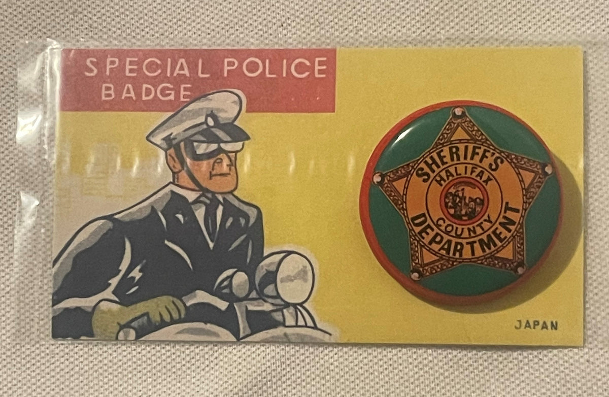 Vintage tin litho packaging for a sheriff's badge pin, showing illustrated policeman on motorcycle on left, brass star badge 