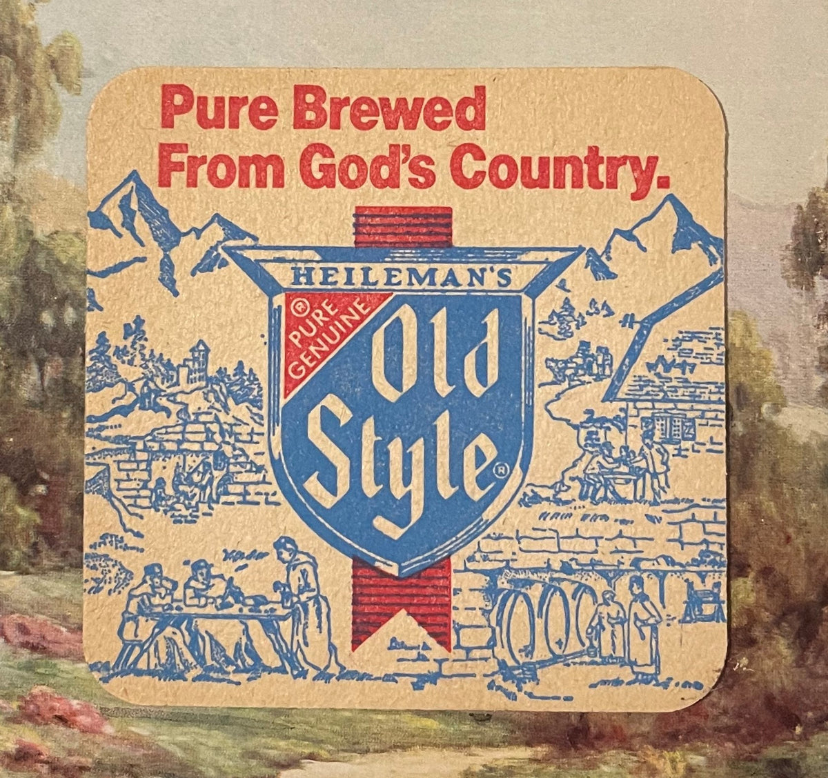 Front of the Heileman's Old Style beer coaster: Pure Brewed From God's Country in red, the blue Old Style shield over a drawing of mountains, a castle and a bridge