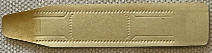 Gilt gold embossed cigar band with decorative dotted border and rectangular panels, shown flat against textured fabric backgr