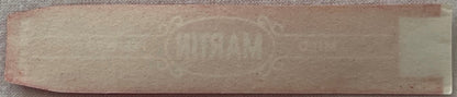 Vintage Martin Mild Perfecto cigar band label with burgundy red embossed text on tan paper, displayed flat against gray fabri