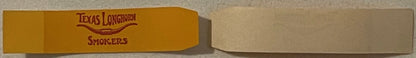 Yellow cigar band with red "Texas Longhorn Smokers" text, photographed at an angle against gray background
