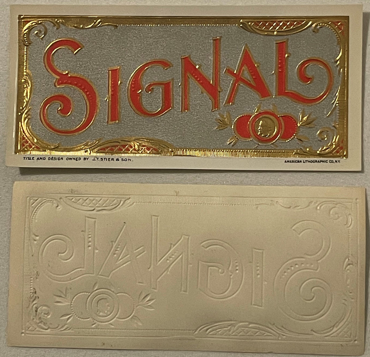 Two antique cigar labels: top shows red and gold embossed "Signal" text on gray ground; bottom shows cream-colored embossed d