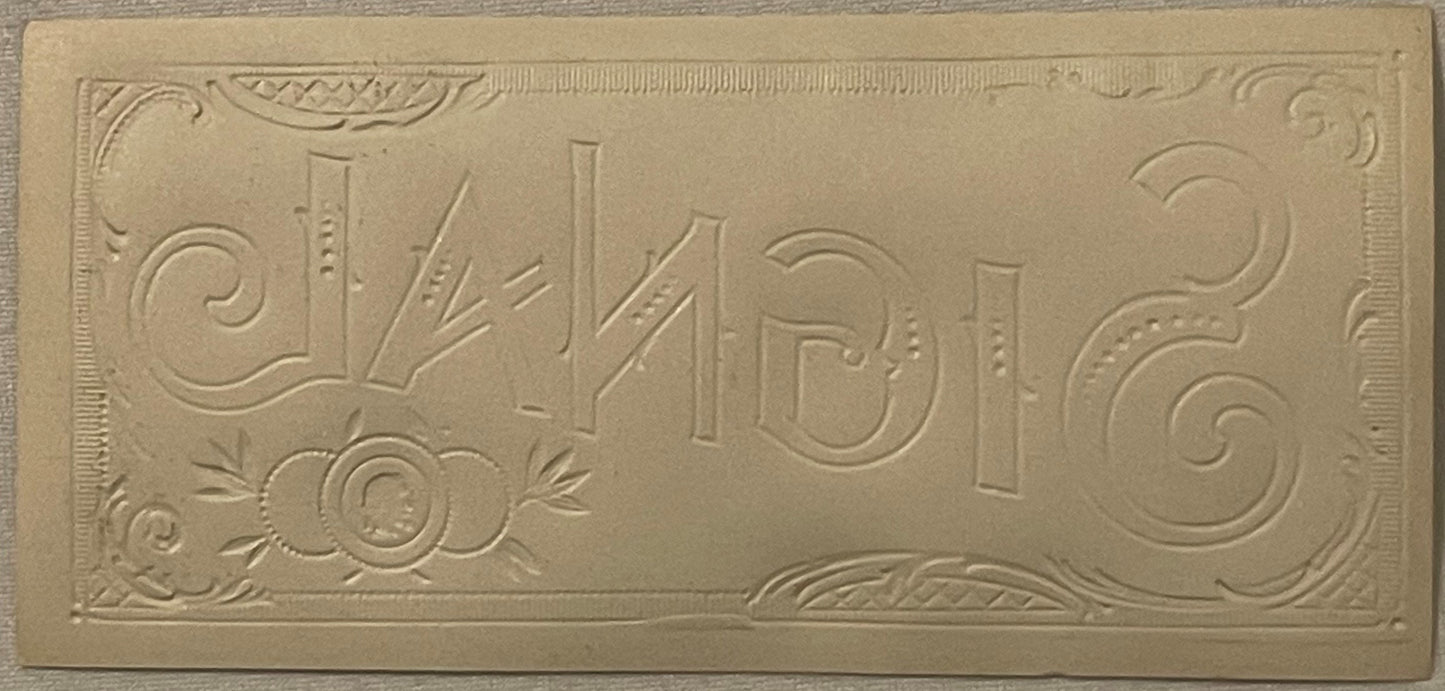 Embossed gold cigar label with "Signal" text and ornamental scrollwork borders on cream-colored paper, photographed flat.