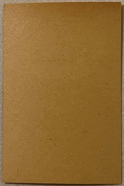 Blank tan cardboard label or tobacco packaging, shown flat against light fabric background