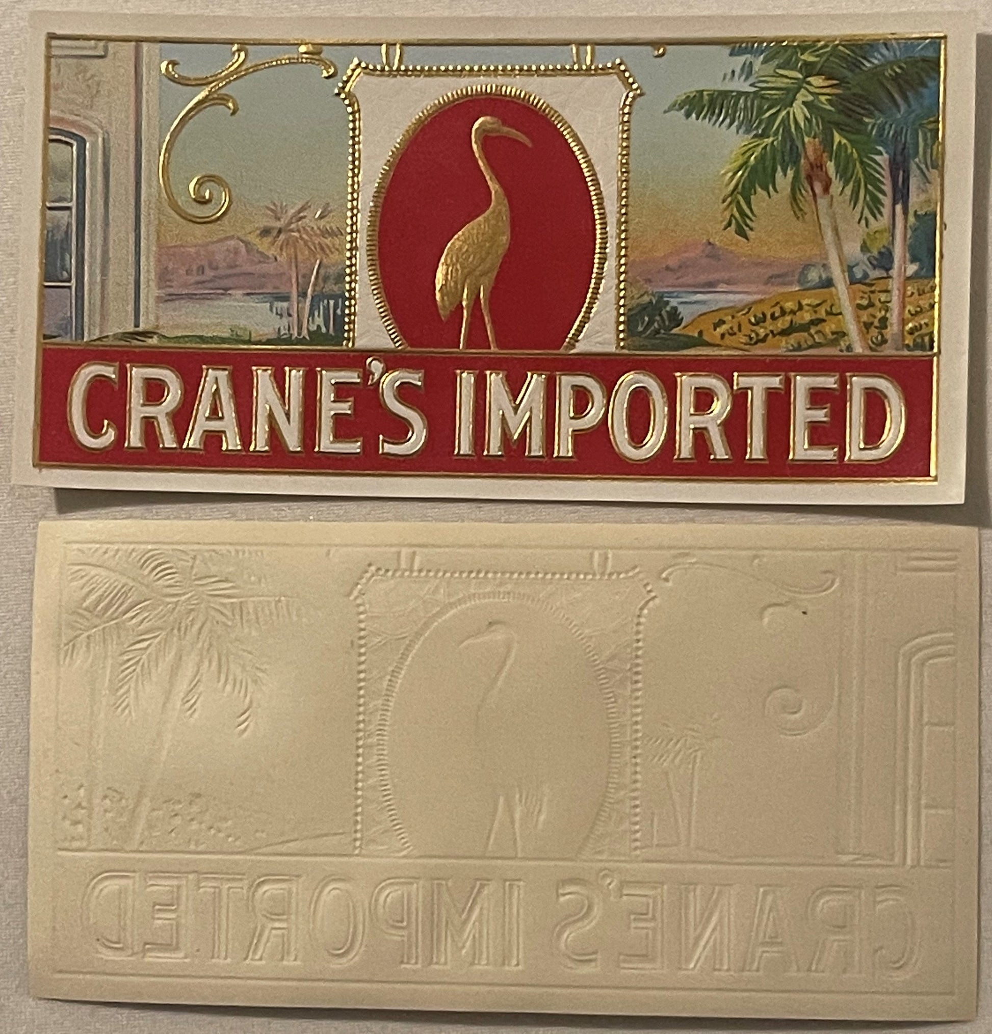 Antique Crane's Imported cigar label showing embossed golden crane on red background, displayed above cream-colored embossed 
