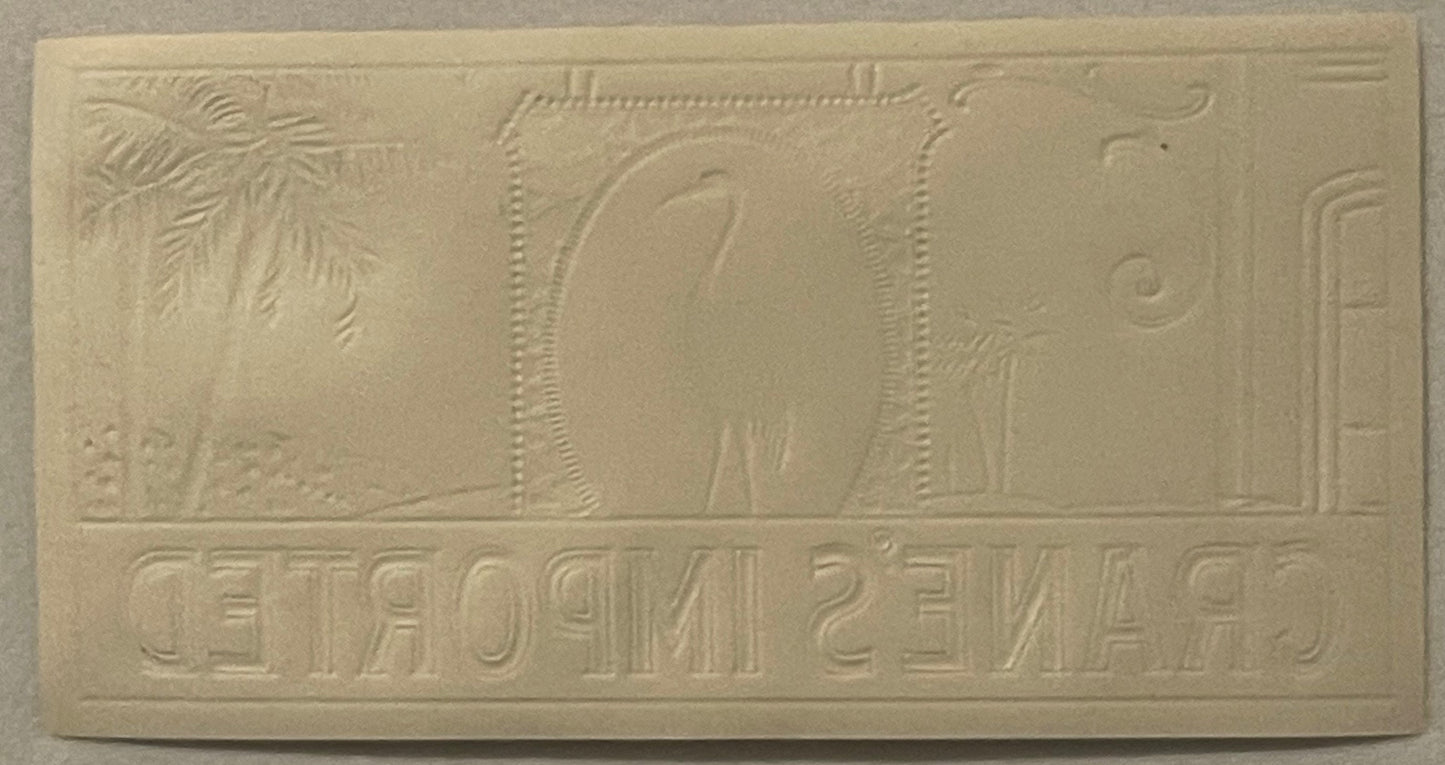Cream-colored embossed cigar label featuring Egyptian imagery with hieroglyphics and decorative borders, photographed flat ag