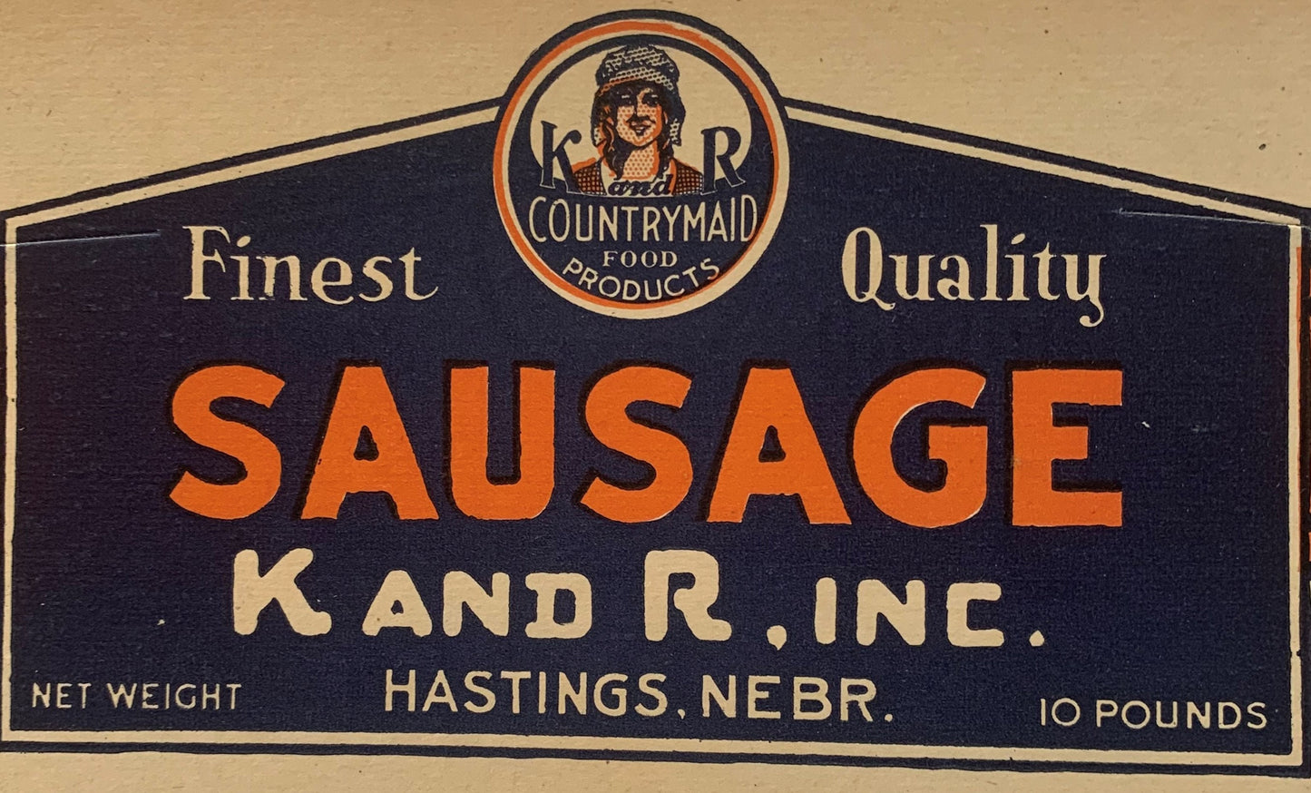Vintage K and R Countrymaid sausage label from Hastings, Nebraska showing woman's portrait, orange and black design, 10 pound