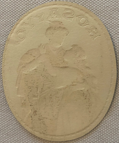 Cream-colored embossed oval cigar label with romantic couple portrait and ornate text border on beige fabric background