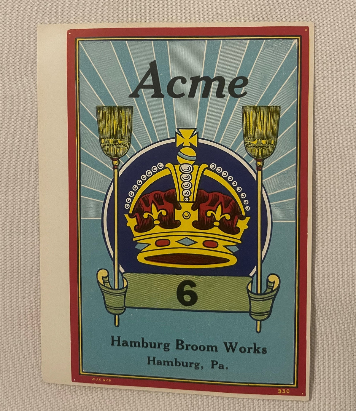 Vintage Acme No. 6 broom label featuring a gold crown with red jewels, two gold brooms, and radiating blue rays on cream back