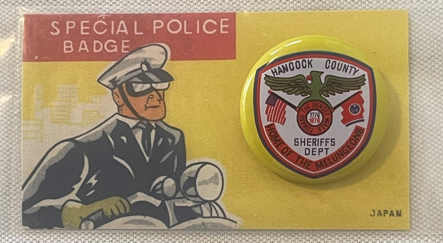 Vintage tin litho pinback button featuring Hancock County Sheriffs Dept eagle logo on yellow backing with illustrated police 